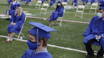 Estudiantes graduados practican la distancia socialmente sentados muy separados durante una ceremonia de graduaci&oacute;n en Millburn High School en Millburn, N.J., el mi&eacute;rcoles 8 de julio de 2020.
 