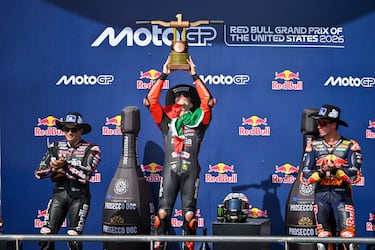 El piloto de Aprilia Racing Team, Marco Bezzecchi, ganador de la carrera levanta el trofeo arropado por Jorge Martín, segundo y Pedro Acosta, tercero.