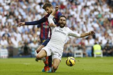 El defensa del Real Madrid Daniel Carvajal (d) lucha un balón con el defensa del FC Barcelona Gerard Piqué durante el partido de la novena jornada de Liga de Primera División disputado esta tarde en el estadio Santiago Bernabéu.