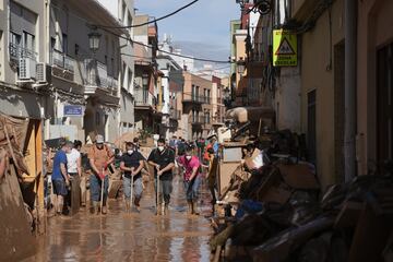 Voluntarios y vecinos ayudan a limpiar en el municipio de Paiporta afectado por las fuertes lluvias que provocaron inundaciones.