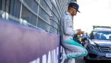 Lewis Hamilton usa su movil en el pit lane antes de la salida en Australia.