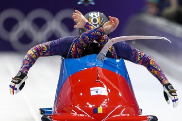 Los rumanos Mihai Cristian Tentea y George Iordache compiten en la primera ronda de bobsleigh masculino en el Cortina Sliding Centre.
