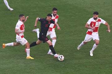 Albania's forward #26 Arber Hoxha (C) runs with the ball surrounded by Croatia's midfielder #08 Mateo Kovacic (L) and Croatia's defender #04 Josko Gvardiol (R) during the UEFA Euro 2024 Group B football match between Croatia and Albania at the Volksparkstadion in Hamburg on June 19, 2024. (Photo by Ronny HARTMANN / AFP)