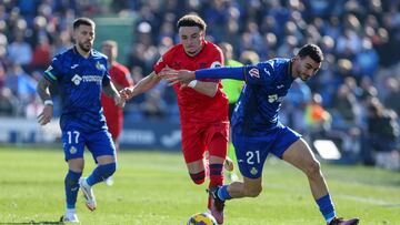 GETAFE (MADRID), 01/02/2025.- El defensa del Getafe Juan Antonio Iglesias pelea por un balón ante el delantero suizo del Sevilla Ruben Vargas (c) durante el partido de la jornada 22 de LaLiga EA Sports que enfrenta al Getafe contra el Sevilla este sábado en el Coliseum en Getafe. EFE/ Kiko Huesca
