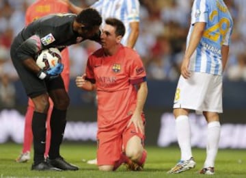 El portero camerunés del Málaga Carlos Kameni atiende al delantero argentino Leo Messi, del FC Barcelona, durante el encuentro de la quinta jornada de Liga en Primera División disputado esta noche en el estadio de La Rosaleda, en Málaga.