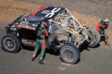 French driver Sebastien Loeb stands near his Dacia Sandrider vehicle after crashing during stage 3 of the 47th Dakar Rally between Bisha and al-Henakiyah, on January 7, 2025. (Photo by Valery HACHE / AFP)