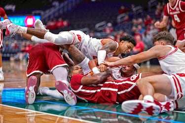 Oklahoma Sooners y Wisconsin Badgers disputaron un partido de exhibición de baloncesto universitario (NCAA) en el Fiserv Forum de Milwaukee (Wisconsin). Sin embargo, la forma de emplearse de los jugadores pareció más propia de una final. En la foto, Tae Davis, de los  Sooners, lucha por un balón suelto con Nick Boyd y Braeden Carrington, de los Badgers. 