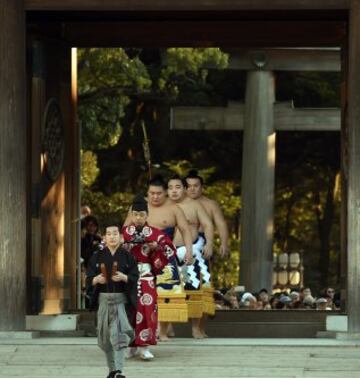 Los campeones de sumo entran en el santuario Meiji para interpretar la tradicional ceremonia de Año Nuevo, en Tokio (Japón). La ceremonia tradicional atrae cada año a miles de personas que no quieren perderse la lucha entre los dos campeones de sumo de Japón, conocidos como yokozuna, considerada como una ofrenda a los dioses sintoístas. 
