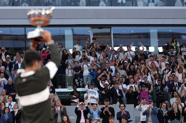 Carlos Alcaraz sostiene el trofeo de Roland Garros ante la mirada del público. 