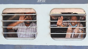 Migrant workers and families wave from the windows of a special train from Amritsar to Gonda in Uttar Pradesh state as they go back to their hometowns after the government eased a nationwide lockdown imposed as a preventive measure against the COVID-19 co