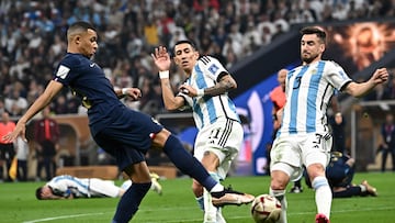 France's forward #10 Kylian Mbappe (L) kicks the ball as Argentina's defender #03 Nicolas Tagliafico (R) and Argentina's midfielder #11 Angel Di Maria (C) react during the Qatar 2022 World Cup final football match between Argentina and France at Lusail Stadium in Lusail, north of Doha on December 18, 2022. (Photo by Anne-Christine POUJOULAT / AFP)