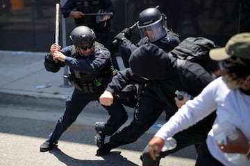  de la Policía Metropolitana de Los Ángeles se enfrentan con manifestantes durante una protesta contra las redadas federales de inmigración en el centro de Los Ángeles.