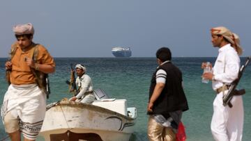 Armed men stand on the beach as the Galaxy Leader commercial ship, seized by Yemen's Houthis last month, is anchored off the coast of al-Salif, Yemen, December 5, 2023. REUTERS/Khaled Abdullah