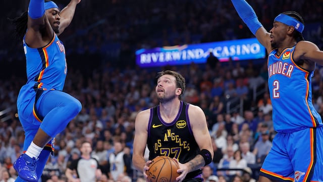 Apr 2, 2026; Oklahoma City, Oklahoma, USA; Los Angeles Lakers guard Luka Doncic (77) drives between Oklahoma City Thunder guard Luguentz Dort (5) and guard Shai Gilgeous-Alexander (2) during the first quarter at Paycom Center. Mandatory Credit: Alonzo Adams-Imagn Images