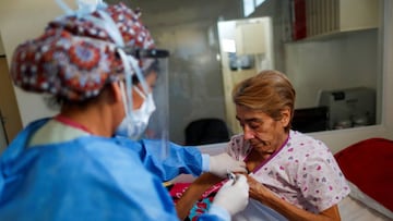 Dr. Mabel Diaz takes the temperature of Elsa Paniagua, who is a coronavirus disease (COVID-19) patient, in an Intensive Care Unit (ICU), at the Dr. Alberto Antranik Eurnekian hospital, in Ezeiza, on the outskirts of Buenos Aires, Argentina August 21, 2020. REUTERS/Agustin Marcarian