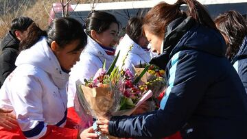 JINCHEON, SOUTH KOREA - JANUARY 25:  North Korean women&#039;s ice hockey players (L) recieve flowers from South Korean players during a welcoming ceremony after arrive at South Korea&#039;s national training center on January 25, 2018 in Jincheon, South 