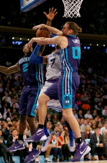 Spencer Hawes y Marvin Williams de los Charlotte Hornets bloquean a Carmelo Anthony de los New York Knicks.