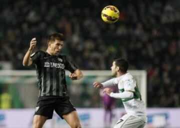 El centrocampista del Málaga Ignacio Camacho (i) despeja ante el centrocampista del Elche Víctor Rodríguez, durante el partido de la decimosexta jornada de Liga de Primera División 