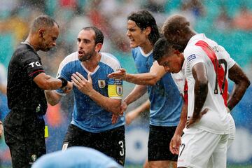 Diego Godín y Edinson Cavani protestan al árbitro Wilton Pereira Sampaio.