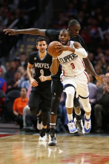 Chris Paul dribla a Gorgui Dieng ante la mirada de Ricky Rubio.