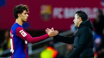 El delantero del Barcelona Joao Félix (i) choca la mano de su entrenador, Xavi Hernández en su camino hacia los vestuarios durante el partido de LaLiga de fútbol que FC Barcelona y Atlético de Madrid disputan este domingo en el Estadio Olímpico de Montjuic.