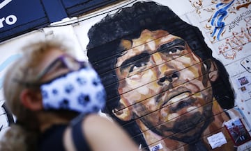 A woman stands in front of a mural of Diego Maradona outside Argentinos Juniors Club at Paternal neighbourhood in Buenos Aires, Argentina.