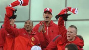 Los jugadores del Manchester United, Ashley Young, Rio Ferdinand y Tom Cleverley celebran junto al resto del equipo el t&iacute;tulo de la Premier League en un autob&uacute;s que recorre las calles de Manchester, Reino Unido hoy 13 de mayo de 2013. 