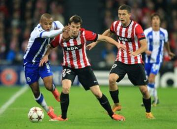 El centrocampista argelino del Oporto Yacine Brahimi (i) lucha un balón con los jugadores del Athletic Club Guillermo Fernández (c) y Óscar de Marcos, durante el partido de la fase de grupos de Liga de Campeones, disputado hoy en el estadio de San Mamés, en Bilbao.