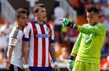 El delantero croata del Atlético de Madrid Mario Mandzukic (2i), junto al delantero del Valencia Rodrigo Moreno (i) y el portero brasileño Diego Alves (d).