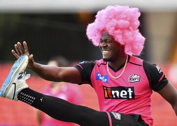 Carlos Brathwaite, jugador de los Sixers nacido en Barbados y ex capitán del equipo internacional de las Indias Occidentales, muestra espíritu navideño al calentar con una peluca rosa antes del partido de cricket de la Big Bash League (BBL), de Australia, entre Adelaide Strikers y Sydney Sixers en el Metricon Stadium de Gold Coast.