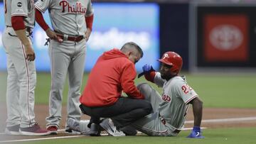 Philadelphia Phillies&#039; Andrew McCutchen, right, is helped by a trainer after being injured while trying to get back to first base during the first inning of a baseball game against the San Diego Padres, Monday, June 3, 2019, in San Diego. Phillies manager Gabe Kapler, left, watches alongside first base coach Paco Figueroa. (AP Photo/Gregory Bull)