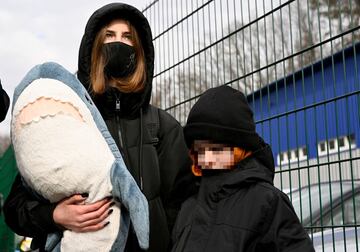 A young woman with a baby and a young child waits to cross the Ukrainian border into Slovakia, to flee from Russian air attacks.