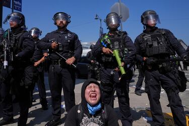 Maribel Parra grita mientras los manifestantes se enfrentan a una línea policial cerca del centro de detención metropolitano del centro de Los Ángeles.