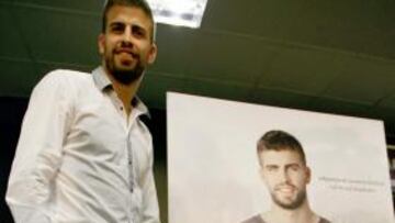 <b>PROTAGONISTA. </b>El futbolista, ayer, junto a la portada de su libro.