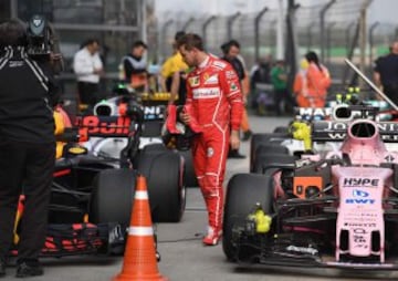 Sebastian Vettel looks at Daniel Ricciardo's car.