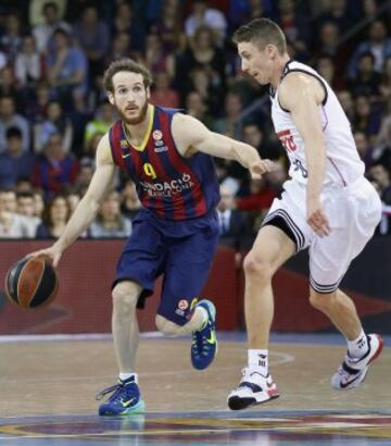 El base brasileño del Barcelona Marcelinho Huertas intenta avanzar ante la oposición del escolta estadounidense del Real Madrid Jaycee Carroll.