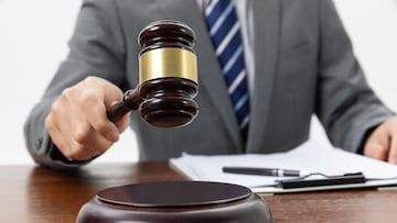 A closeup shot of a person holding a gavel on the table
