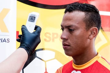 Una empleado controla la temperatura de Christian Reyes, jugador del Sport Herediano, en el vestuario del equipo. Los clubes profesionales de fútbol de Costa Rica volvieron a los entrenamientos tras más de un mes de confinamiento por el coronavirus.