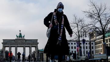 Berlin (Germany), 11/01/2022.- A pedestrian wears a face mask in-front of the Brandenburg Gate in Berlin, Germany, 11 January 2022. Stricter Covid-19 measures were passed during a conference of German regional state ministers which include further social distance and face mask restrictions on unvaccinated and vaccinated citizens. (Alemania) EFE/EPA/FILIP SINGER