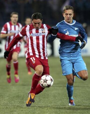 El centrocampista uruguayo del Atlético de Madrid, Cristian 'Cebolla' Rodríguez (i) lucha por el balón con Domenico Criscito (d) del Zenit de San Petersburgo durante el partido correspondiente a la fase de grupos de la Liga de Campeones disputado en el estadio Petrovsky de San Petersburgo