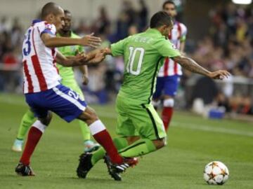 El defensa brasileño del Atlético de Madrid Joao Miranda (i) lucha el balón con el argentino Carlos Tévez, de la Juventus, durante el partido de la segunda jornada de la fase de grupos de la Liga de Campeones que se disputa esta noche en el estadio Vicente Calderón, en Madrid.