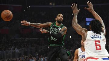 Kyrie Irving da un pase ante la ayuda de DeAndre Jordan.