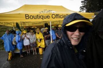 Espectadores se protegen de la lluvia.