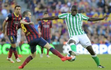 El centrocampista del Barcelona Andrés Iniesta (i) y el centrocampista del Betis Alfred N'Diaye luchan por el balón.