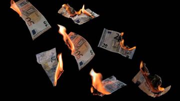 Burning money, twenty and fifty euro banknotes with flames flying isolated against a black background, concept for inflation, finance, investment risk and currency, copy space, selected focus