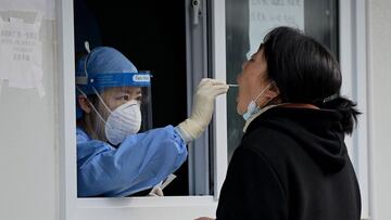 A health worker takes a swab sample from a woman to be tested for Covid-19 coronavirus in Beijing on October 28, 2021. (Photo by Noel Celis / AFP)