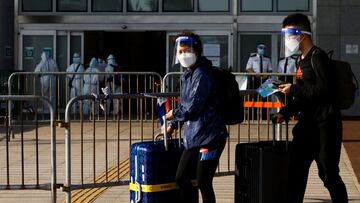 Travellers wearing face mask and shield, walk at the China-Hong Kong border of Shenzhen Bay Port, during the coronavirus disease (COVID-19) pandemic in Hong Kong, China, March 14, 2022. REUTERS/Tyrone Siu