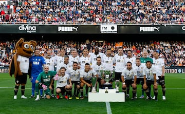 Los miembros de la plantilla del Valencia 2003-2004 y 2004-2005 posan con los trofeos.