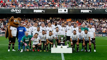 Los miembros de la plantilla del Valencia 2003-2004 y 2004-2005 posan con los trofeos.