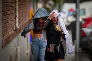 Dos mujeres se cubren de la lluvia en la ciudad de Madrid. 